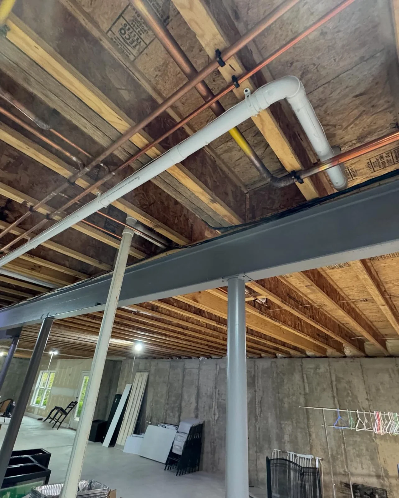 Central vacuum tubing above an open ceiling