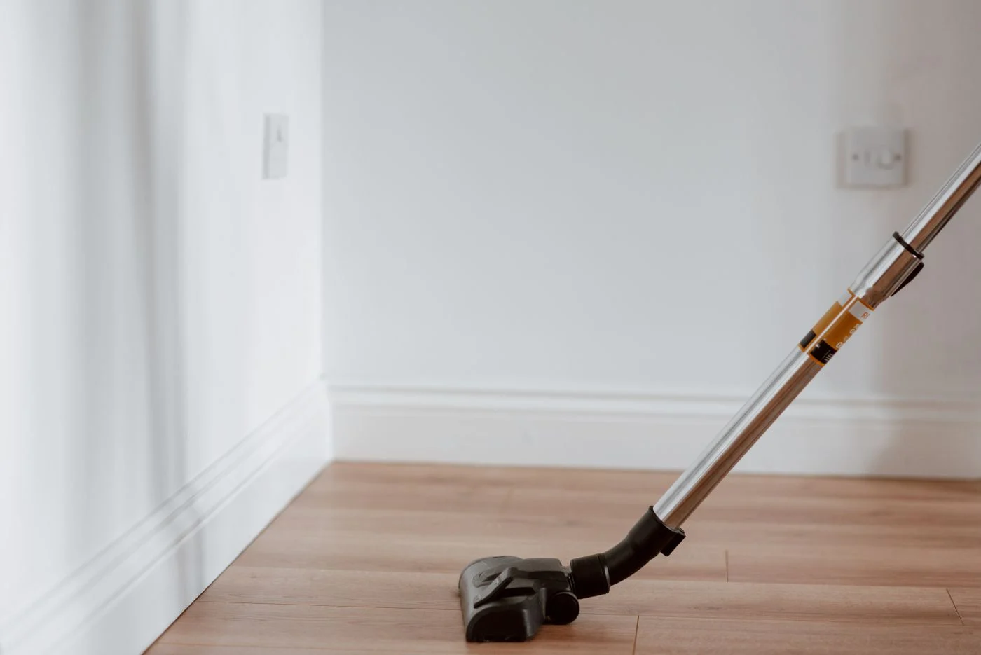 Vacuum cleaning a bright wood floor in a clean room