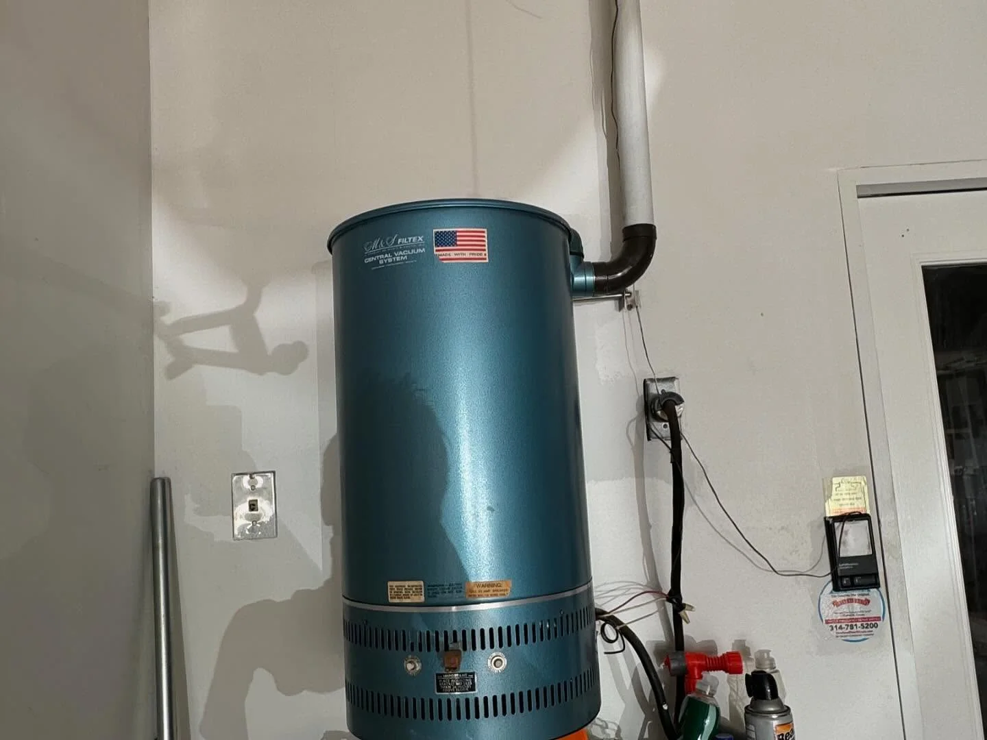 Older central vacuum power unit mounted on a wall